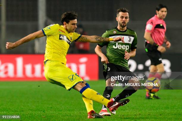 Chievo's Serbian midfielder Ivan Radovanovic kicks the ball despite Juventus' Bosnian midfielder Miralem Pjanic during the Italian Serie A football...