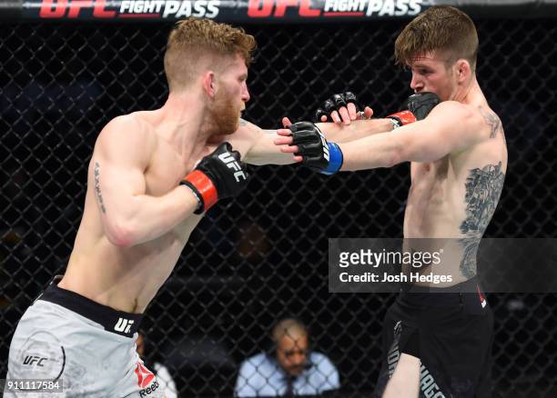 Austin Arnett punches Cory Sandhagen in their featherweight bout during a UFC Fight Night event at Spectrum Center on January 27, 2018 in Charlotte,...