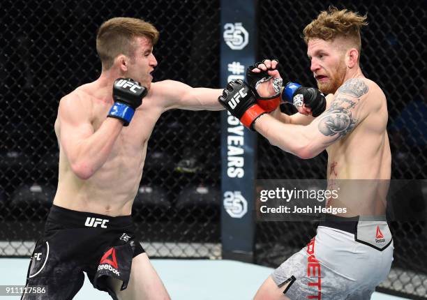 Cory Sandhagen punches Austin Arnett in their featherweight bout during a UFC Fight Night event at Spectrum Center on January 27, 2018 in Charlotte,...