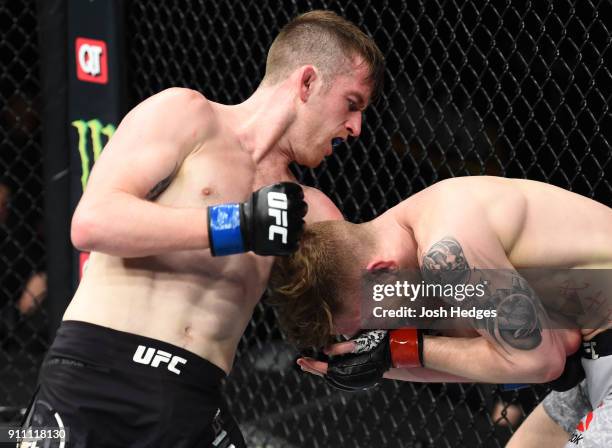 Cory Sandhagen punches Austin Arnett in their featherweight bout during a UFC Fight Night event at Spectrum Center on January 27, 2018 in Charlotte,...