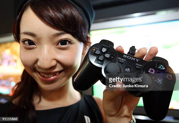 Woman holds the controller of a new PlayStation 3 which was released in September 2009 at Sony Computer Entertainment booth during the Tokyo Game...