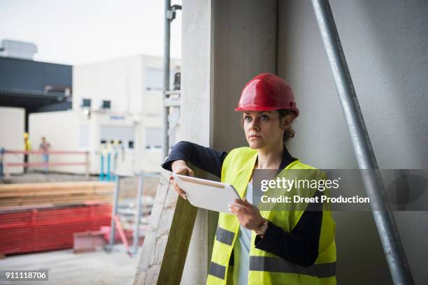 female architect with digital tablet at construction site - vorarbeiter stock-fotos und bilder