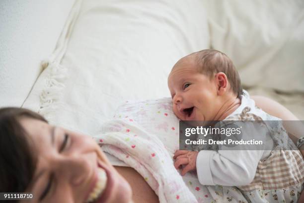 happy mother cradling newborn baby girl in her arms - baby happy cute smiling baby only stockfoto's en -beelden