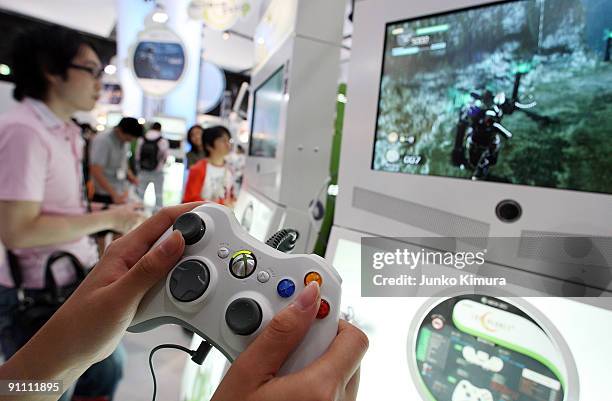 Visitors play with the XBOX 360 at the Microsoft booth during the Tokyo Game Show 2009 press and business day at Makuhari Messe on September 24, 2009...