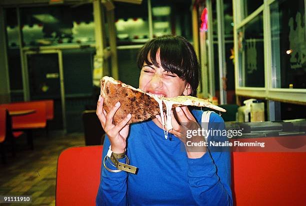 woman eating a large piece of pizza. - american pizza stock-fotos und bilder