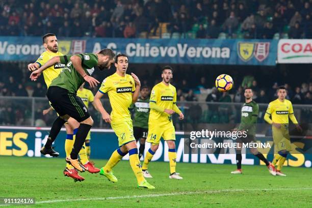 Juventus' Argentinian forward Gonzalo Higuain scores a header during the Italian Serie A football match AC Chievo vs Juventus at the...
