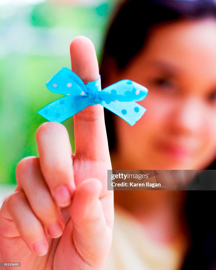 Woman holding up her pointer finger wrapped with a