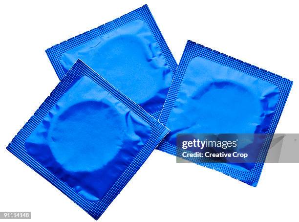 three condoms in wrappers - condon fotografías e imágenes de stock