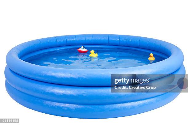 inflatable swimming pool with rubber duck and toy  - paddling pool stock pictures, royalty-free photos & images