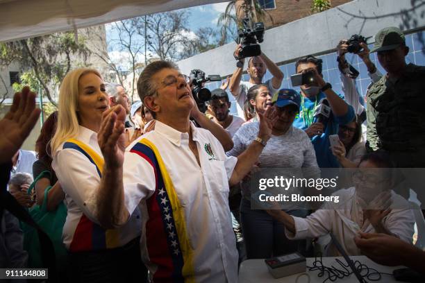 Henry Ramos Allup, president of the Accion Democratica party and former president of the National Assembly, center, reacts after signing a testament...