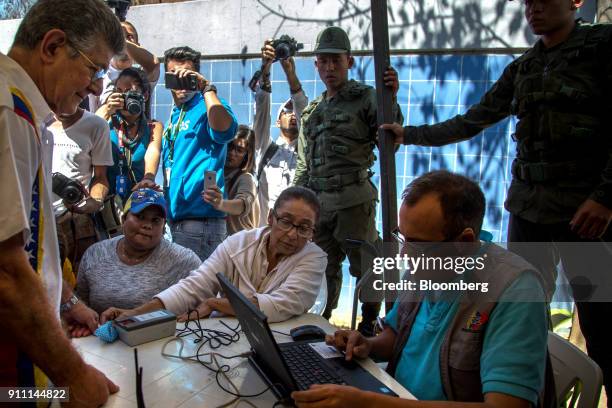 Henry Ramos Allup, president of the Accion Democratica party and former president of the National Assembly, left, signs a testament for...