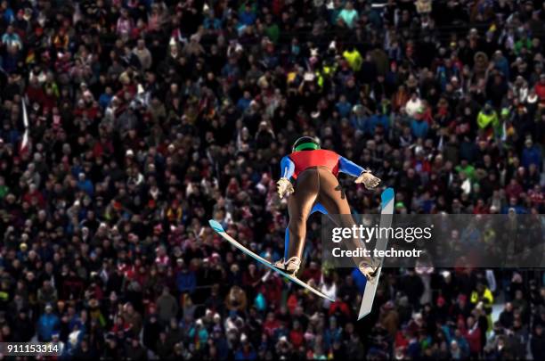 rear view of male ski jumper in mid-air - ski jump stock pictures, royalty-free photos & images