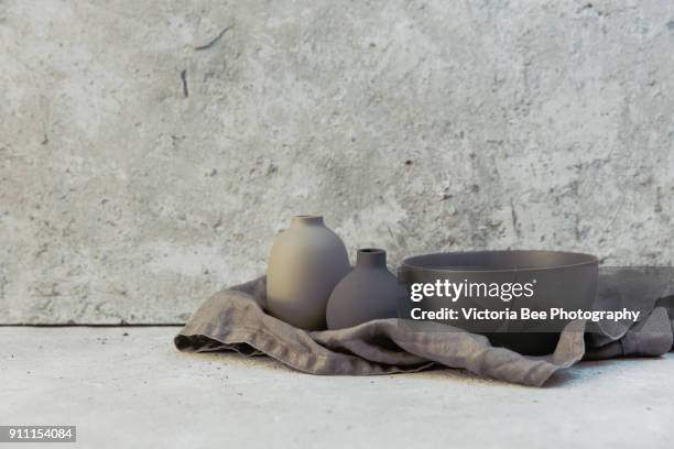 home decor - various neutral colored vases on rough distressed wooden shelf against grey wall. - naturaleza muerta fotografías e imágenes de stock