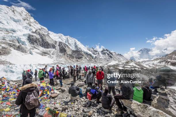 large group of tourists standing at mount everest base camp in sunshine - base camp stock pictures, royalty-free photos & images