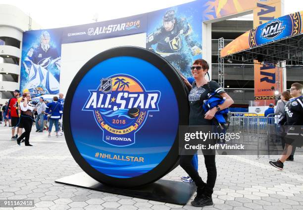 Hockey fan poses next to a large puck prop at the PreGame & Mascot Showdown at Amalie Arena on January 27, 2018 in Tampa, Florida.