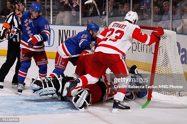 Aaron Voros of the New York Rangers crashes into the net with goaltender Dan Cloutier of the Detroit Red Wings during a preseason game on September...