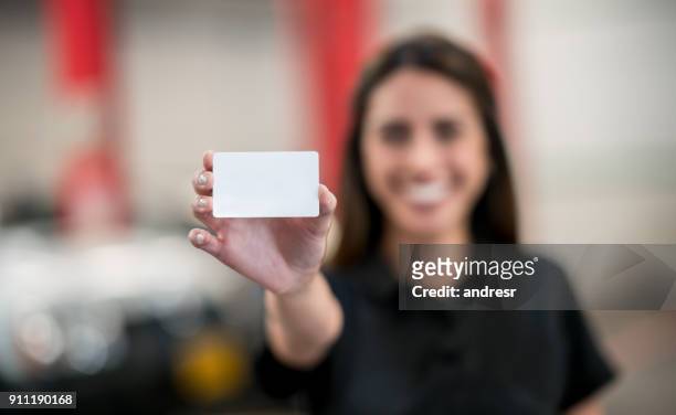 woman at an auto repair shop holding a business card - business card template stock pictures, royalty-free photos & images