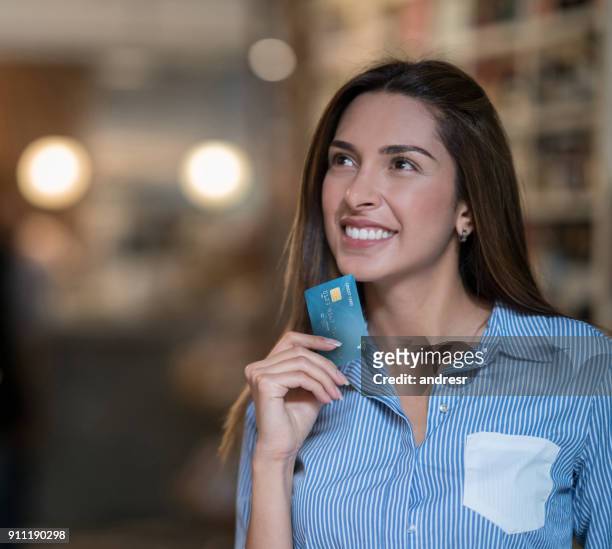 mulher pensativa compras segurando um cartão de crédito - thinking of you card - fotografias e filmes do acervo