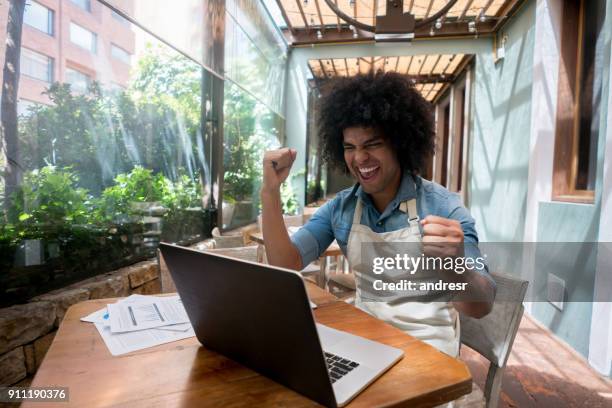 excited business manager doing the books at a restaurant - man atm smile stock pictures, royalty-free photos & images