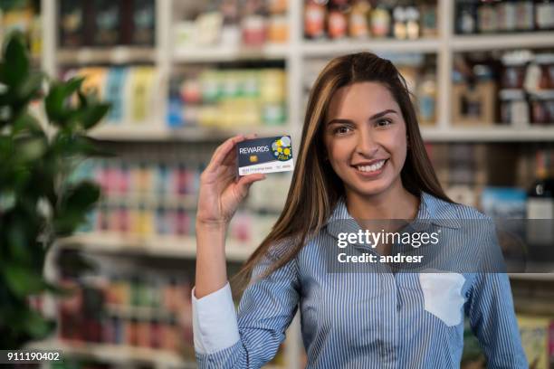 cliente en un mercado con una tarjeta de recompensa - tarjeta de lealtad fotografías e imágenes de stock