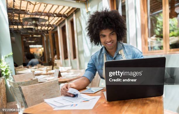 business manager doing the books at a restaurant - man atm smile stock pictures, royalty-free photos & images
