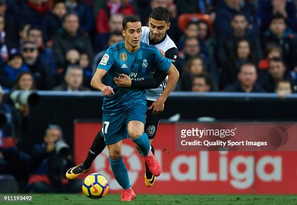 Lucas Vazquez of Real Madrid is tackled by Andreas Pereira of Valencia during the La Liga match between Valencia and Real Madrid at Estadio Mestalla...