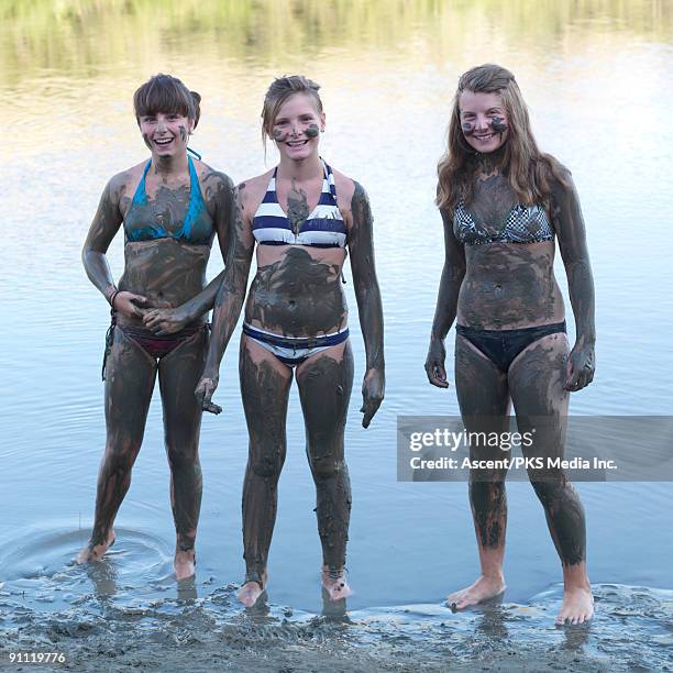 three girls covered in mud, at river's edge - ankle deep in water stock pictures, royalty-free photos & images