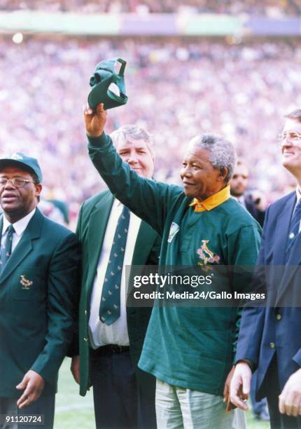 South African president Nelson Mandela, dressed in a No 6 Springbok jersey, celebrates after South Africa beat the All Blacks by 15-12 to win the...
