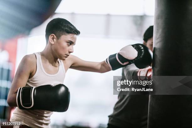 hombre joven en centro de entrenamiento de kickboxing - kick boxing fotografías e imágenes de stock