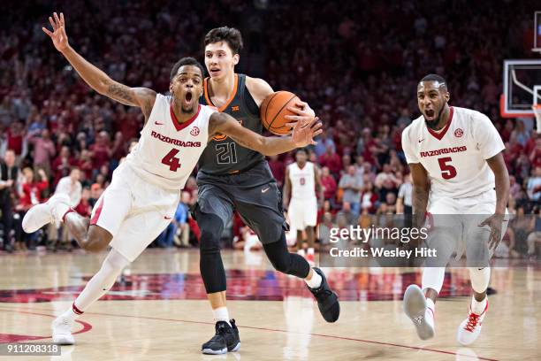 Daryl Macon of the Arkansas Razorbacks is called for a foul while trying to make a steal from Lindy Waters III of the Oklahoma State Cowboys at Bud...