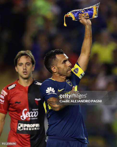 Boca Juniors' Carlos Tevez holds up the team standard after their Argentina First Division Superliga football match against Colon at La Bombonera...