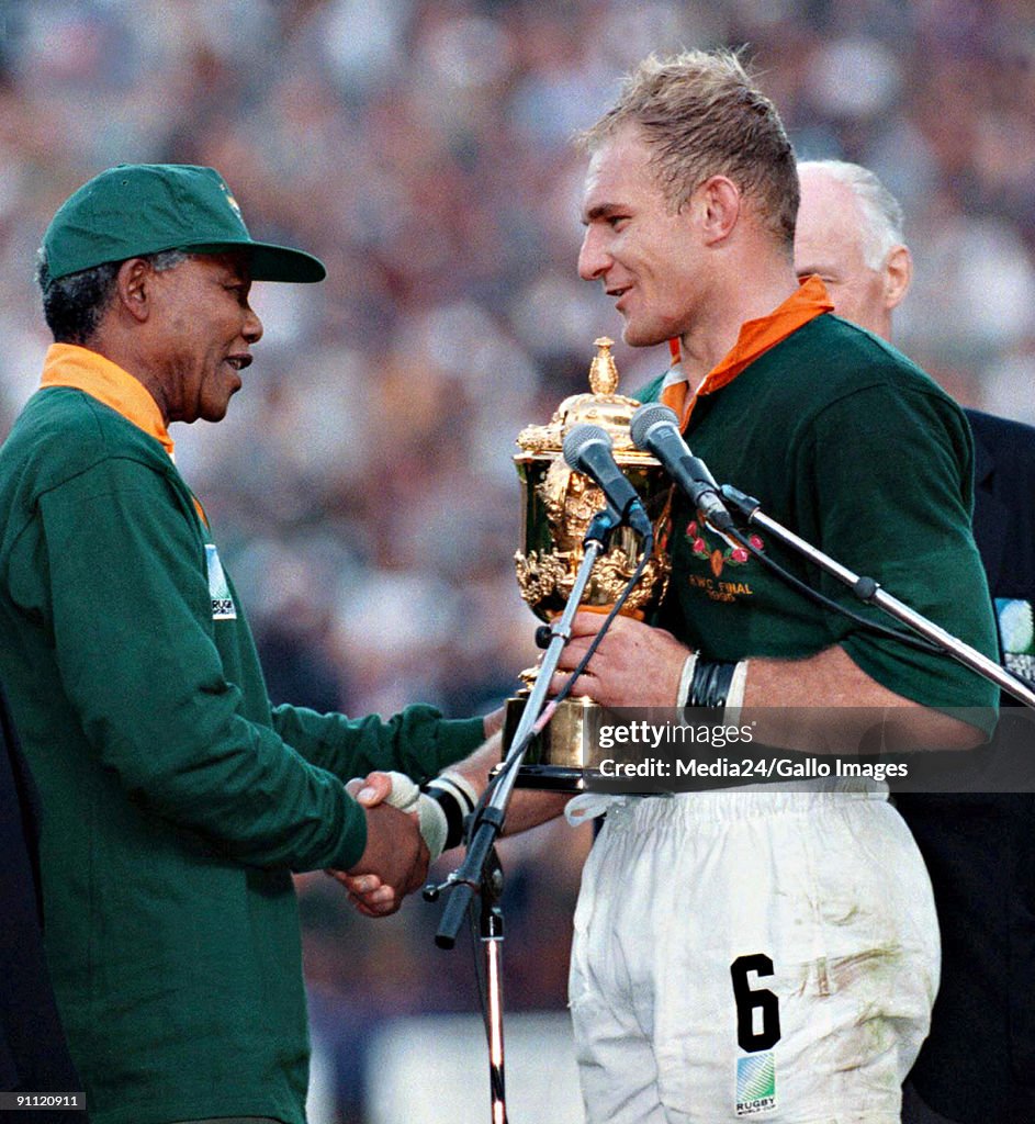 South African president Nelson Mandela, dressed in a No 6 Springbok jersey, congratulates the Springbok captain Francois Pienaar after South Africa beat the All Blacks by 15-12 to win the 1995 Rugby World Cup.