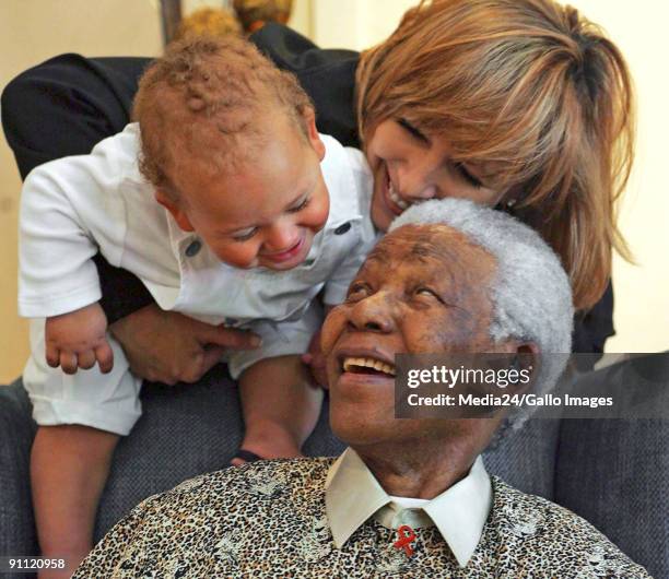 South African rugby player,Chester Williams' wife, Maria and baby sharing a moment with Nelson Mandela.