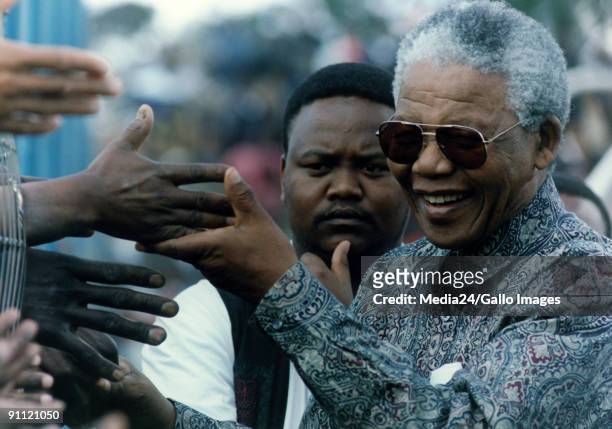 President Nelson Mandela greets the masses, shaking there hands.