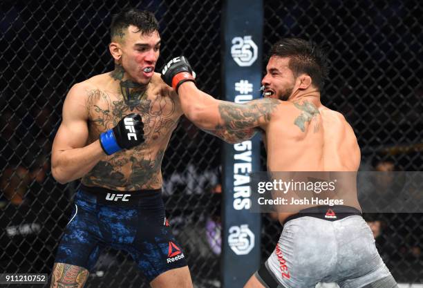 Andre Fili punches Dennis Bermudez in their featherweight bout during a UFC Fight Night event at Spectrum Center on January 27, 2018 in Charlotte,...