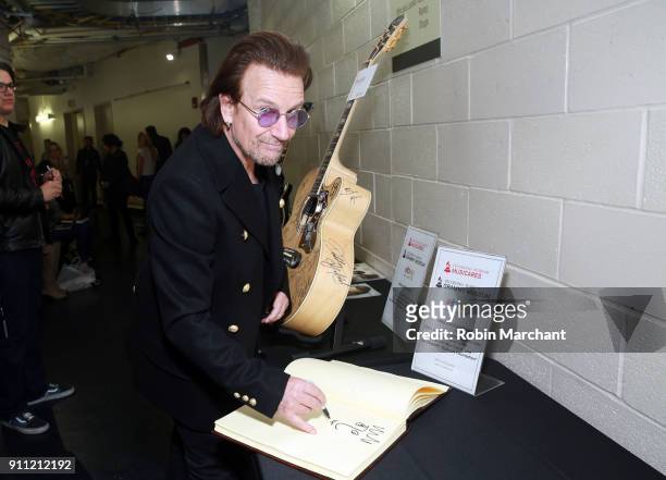 Musician Bono of musical group U2 poses with the GRAMMY Charities Signings during the 60th Annual GRAMMY Awards at Madison Square Garden on January...