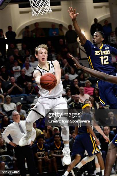 Fletcher Magee guard Wofford College Terriers passes the basketball from under the basket against Jalan McCloud guard East Tennessee State University...