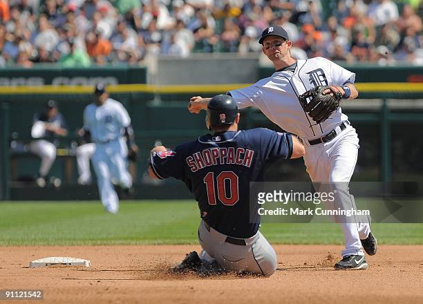 Adam Everett of the Detroit Tigers throws to first base while avoiding the sliding Kelly Shoppach of the Cleveland Indians during the game at...