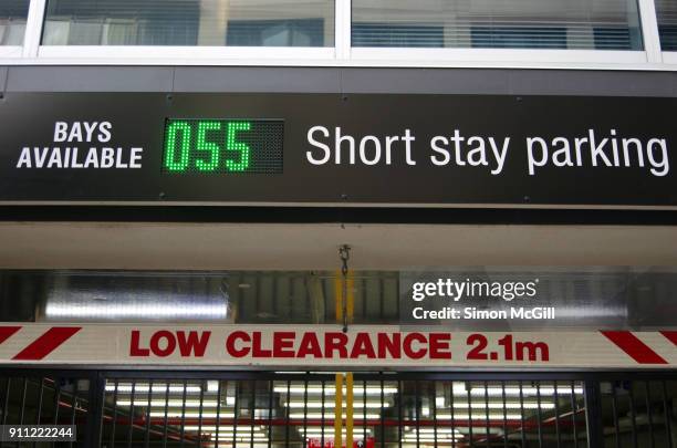 low clearance of 2.1 metres and parking bay count signs at the entrance to a short-stay parking garage - frase breve fotografías e imágenes de stock