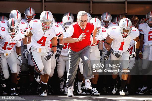 Quarterback Kurt Coleman and head coach Jim Tressel of the Ohio State Buckeyes jog onto the field before the game against the Toledo Rockets at...