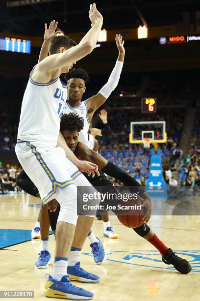 Daejon Davis of the Stanford Cardinal collides with Gyorgy Goloman and Jaylen Hands of the UCLA Bruins in the first half at Pauley Pavilion on...