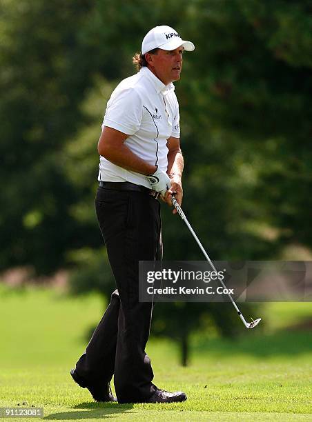 Phil Mickelson watches his second shot from the eighth fairway during the first round of THE TOUR Championship presented by Coca-Cola, the final...