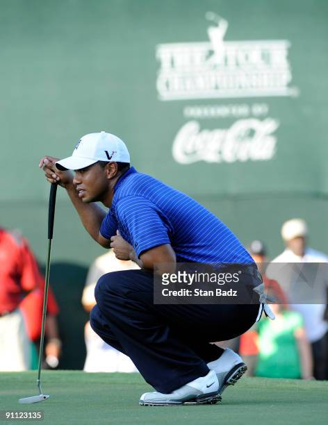 Tiger Woods checks his line on the 18th green during the first round of THE TOUR Championship presented by Coca-Cola, the final event of the PGA TOUR...