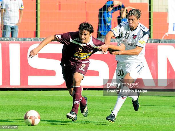 Enrique Vera of Ecuador's Liga Deportiva Universitaria vies for the ball with Eduardo Salvio of Argentina's CA Lanus during their Copa Sudamericana...