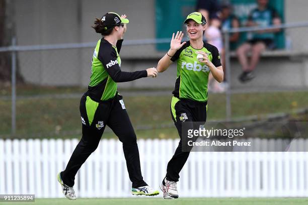 Nicola Carey of the Thunder celebrates with team mates after catching Beth Mooney of the Heat during the Women's Big Bash League match between the...