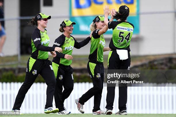 Nicola Carey of the Thunder is congratulated by team mates after catching Beth Mooney of the Heat during the Women's Big Bash League match between...
