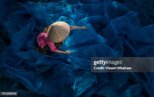 fisherman repair fishing net. - thai tradition stock pictures, royalty-free photos & images