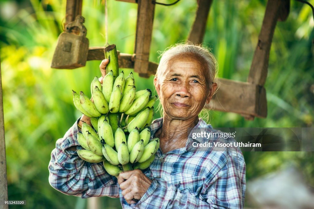 Woman farmer holding green banana