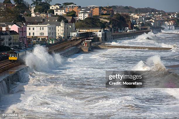 train leaving dawlish station in a storm - high tide stock pictures, royalty-free photos & images
