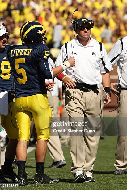 Head coach Rich Rodriguez of the Michigan Wolverines talks with quarterback Tate Forcier during the game with the Eastern Michigan Eagles at Michigan...